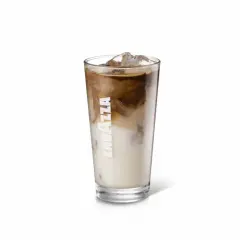 Un bicchiere alto di iced latte Lavazza con cubetti di ghiaccio e striature di caffè e latte.