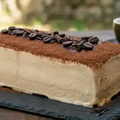 La mattonella della nonna al caffè, ricoperta di cacao e chicchi di caffè, pronta per essere gustata con un espresso.