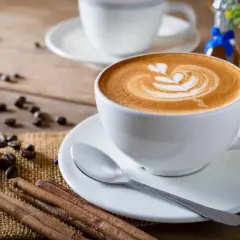 Tazza di cappuccino con latte art, chicchi di caffè e cannella. Nonostante la sua bellezza, la schiuma del cappuccino fa male se consumata in eccesso.