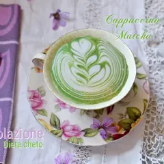 Colazione chetogenica: un cappuccino matcha con latte art verde e bianca, servito in una tazza floreale.