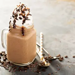 Bevanda fredda al cioccolato con panna montata e sciroppo, ispirata alle ricette Starbucks, con chicchi di caffè e cacao.