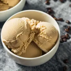 Coppetta di gelato al caffè senza gelatiera e senza latte condensato, con chicchi di caffè sparsi.