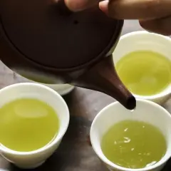 Versando tè verde in tazze. Quante tazze di tè verde bere al giorno? Un rituale rilassante.