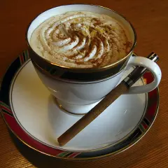 Caffè Pedrocchi ricetta: una tazza di caffè con panna montata, cannella e scorza di limone, accompagnata da un sigaro.