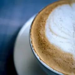 Un delizioso cappuccino al bar, con schiuma soffice e un disegno a cuore.