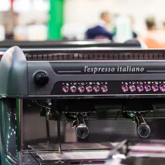 Macchina da caffè professionale, "l'espresso italiano", con pulsanti luminosi e portafiltri pronti per preparare un ottimo caffè.