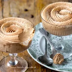 Due coppe di deliziosa mousse di caffè, guarnite a spirale, su un piatto decorato.