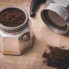 Il filtro moka incastrato è pronto per un caffè aromatico. Caffè macinato fine su tela di juta.