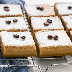 Deliziosi dolci al caffè, cosparsi di zucchero a velo e decorati con chicchi di caffè, pronti per essere gustati.