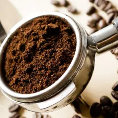 Portafiltro pieno di caffè macinato, pronto per la macchina caffè. Lui ha problemi a preparare un espresso perfetto.