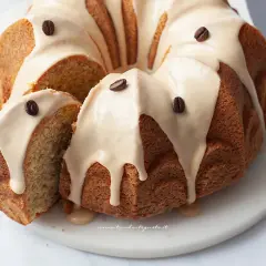 Delizioso ciambellone al caffè senza burro, con glassa e chicchi di caffè. Perfetto per la colazione o la merenda.