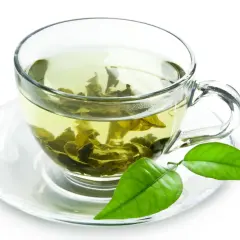 Tazza di tè verde con foglie infuse, un invito a scoprire i suoi benefici.