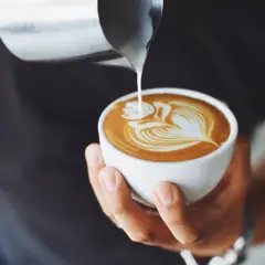 Un barista esperto crea un disegno latte art su un cappuccino, mostrando come fare il cappuccino perfetto.