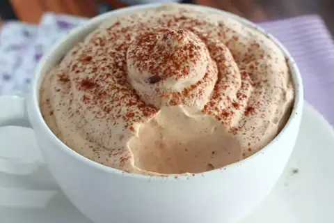Una tazza di caffè con abbondante schiuma cremosa, spolverata di cacao. Un vero piacere per gli amanti del caffè con Nutella.
