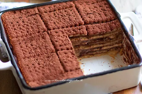 Mattonella al caffè con oro Saiwa, stratificata e spolverata di cacao, un dolce goloso pronto da gustare.