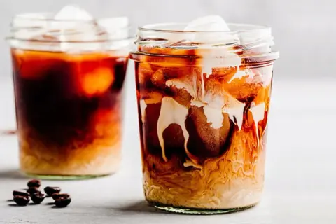 Due bicchieri di iced coffee con ghiaccio e latte che si mescola, un'idea su iced coffee come si fa.
