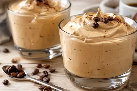 Deliziosa crema caffè in bottiglia, guarnita con chicchi di caffè e cacao. Perfetta per una pausa golosa.