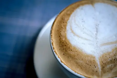 Un delizioso cappuccino al bar, con schiuma soffice e un disegno a cuore.