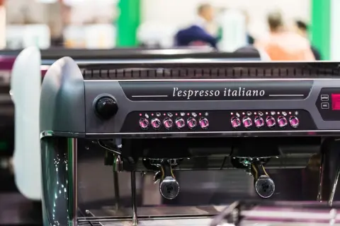 Macchina da caffè professionale, "l'espresso italiano", con pulsanti luminosi e portafiltri pronti per preparare un ottimo caffè.