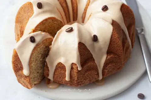 Delizioso ciambellone al caffè senza burro, con glassa e chicchi di caffè. Perfetto per la colazione o la merenda.