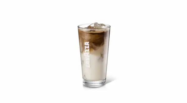 Un bicchiere alto di iced latte Lavazza con cubetti di ghiaccio e striature di caffè e latte.