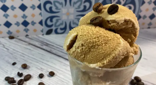 Deliziosa granita di caffè fatta in casa, servita in un bicchiere con chicchi di caffè tostati.