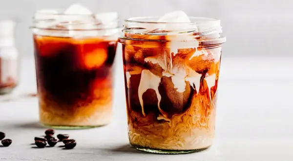 Due bicchieri di iced coffee con ghiaccio e latte che si mescola, un'idea su iced coffee come si fa.