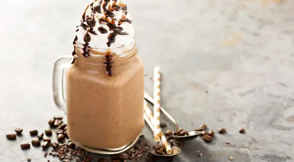 Bevanda fredda al cioccolato con panna montata e sciroppo, ispirata alle ricette Starbucks, con chicchi di caffè e cacao.