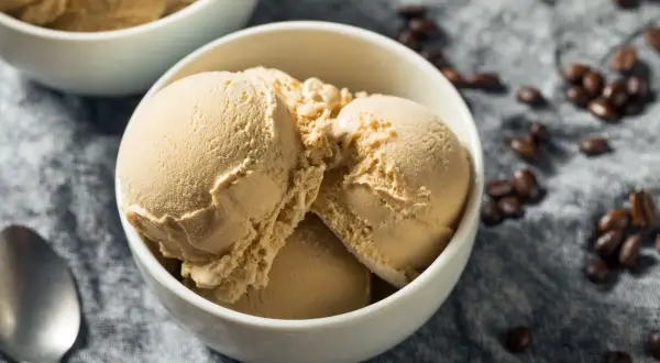 Coppetta di gelato al caffè senza gelatiera e senza latte condensato, con chicchi di caffè sparsi.