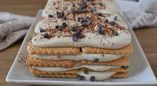 Deliziosa mattonella al caffè con strati di biscotti, crema soffice e gocce di cioccolato, spolverata di cacao.