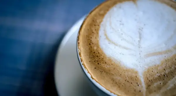 Un delizioso cappuccino al bar, con schiuma soffice e un disegno a cuore.