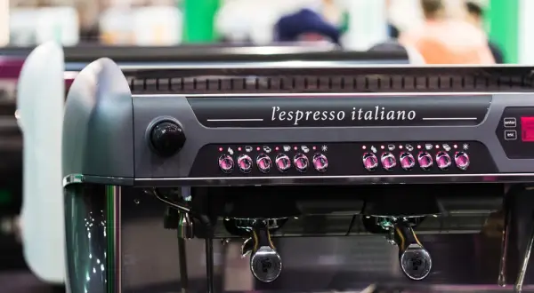 Macchina da caffè professionale, "l'espresso italiano", con pulsanti luminosi e portafiltri pronti per preparare un ottimo caffè.