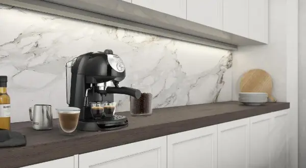 Macchina da caffè DeLonghi EC 201 CD B con due espresso pronti. Nessun problema visibile, solo un'elegante cucina moderna.