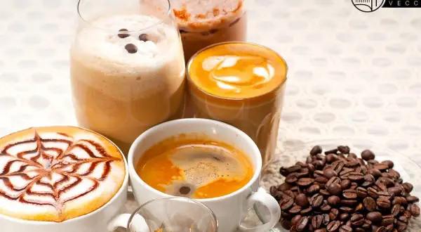 Varietà di deliziosi caffè italiani: un espresso, un cappuccino decorato, un caffè macchiato e un frappé. Chicchi di caffè tostati completano la scena.