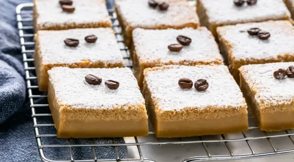Deliziosi dolci al caffè, cosparsi di zucchero a velo e decorati con chicchi di caffè, pronti per essere gustati.