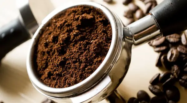 Portafiltro pieno di caffè macinato, pronto per la macchina caffè. Lui ha problemi a preparare un espresso perfetto.