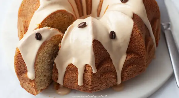 Delizioso ciambellone al caffè senza burro, con glassa e chicchi di caffè. Perfetto per la colazione o la merenda.