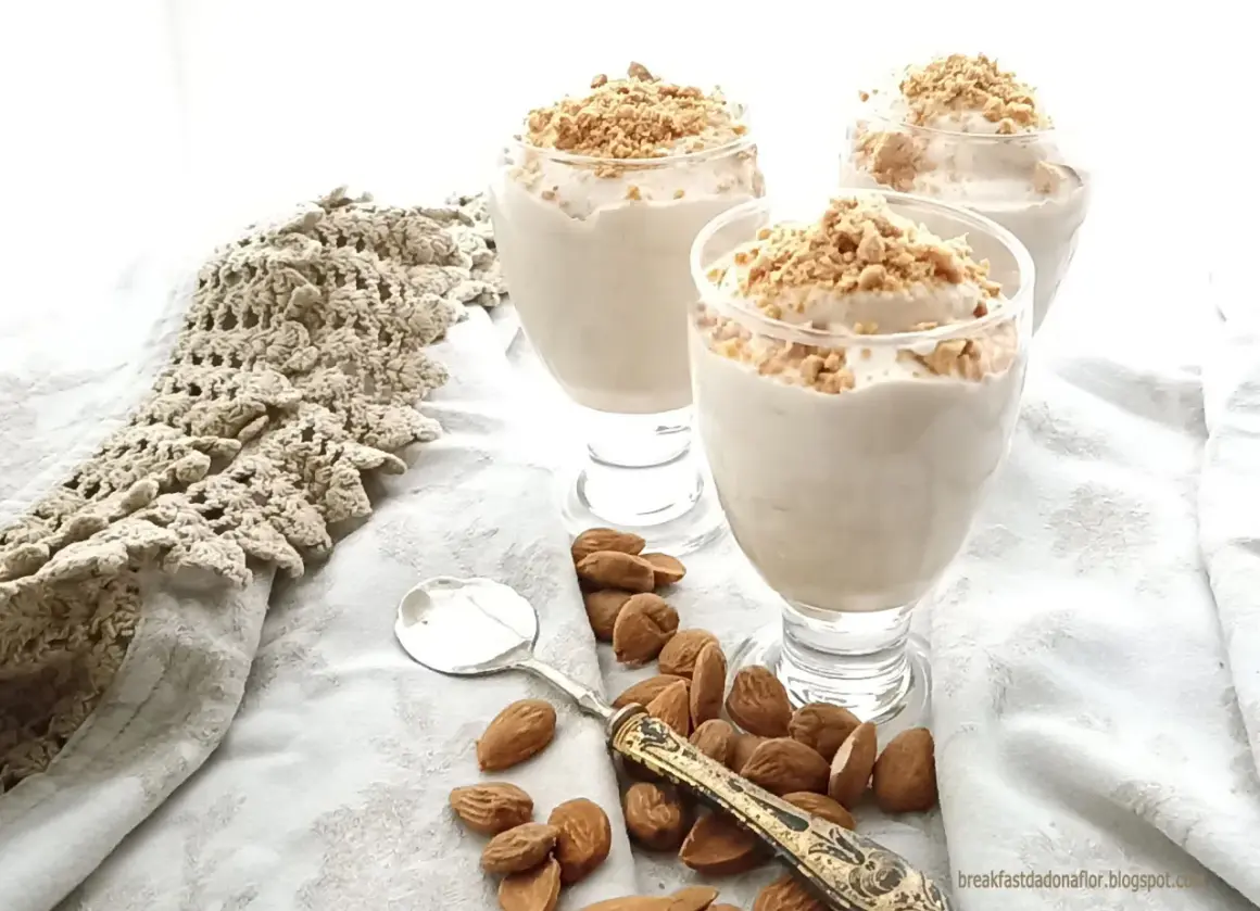 Delizioso espressino freddo pugliese in bicchieri, guarnito con mandorle tritate. Accanto, mandorle intere e un cucchiaino.