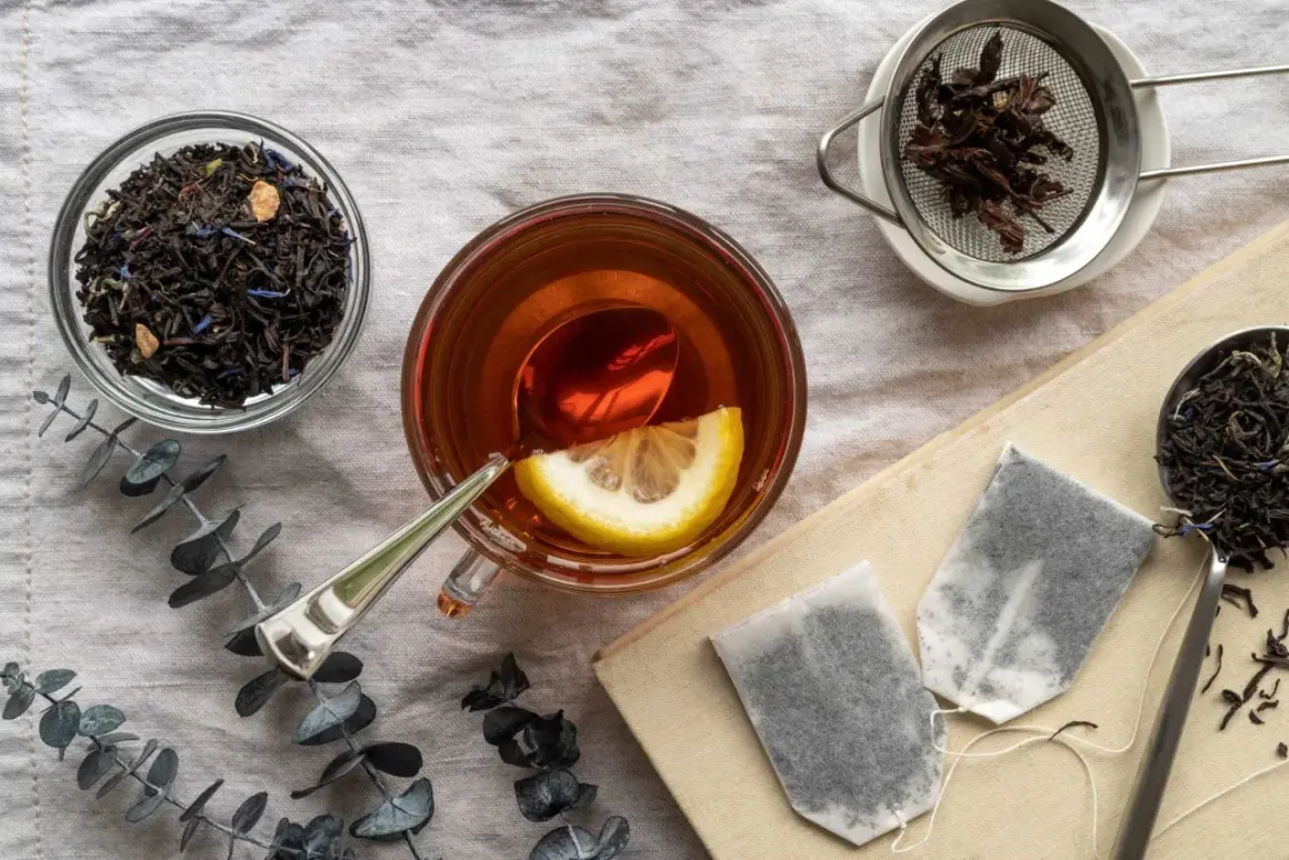 Tazza di tè Earl Grey con limone, foglie di tè sfuse e bustine. Scopri i benefici del tè Earl Grey per il tuo benessere.
