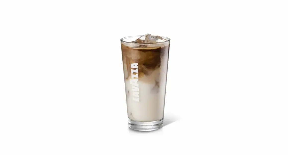 Un bicchiere di iced coffee Lavazza con latte e caffè che si mescolano, pieno di ghiaccio.