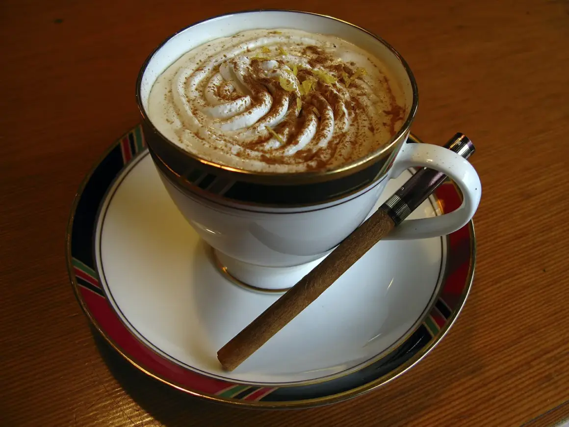 Caffè Pedrocchi ricetta: una tazza di caffè con panna montata, cannella e scorza di limone, accompagnata da un sigaro.