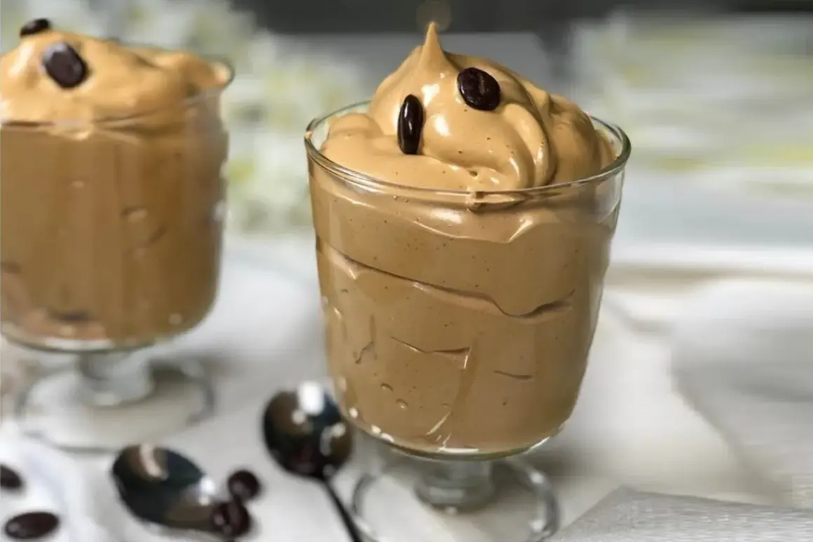 Deliziosa spuma di caffè in bicchieri, guarnita con chicchi di caffè. Perfetta per una pausa golosa.