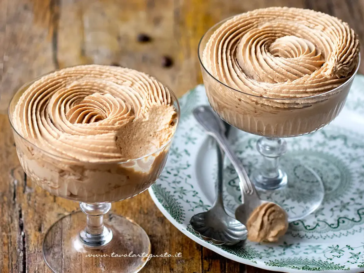 Due coppe di deliziosa mousse di caffè, guarnite a spirale, su un piatto decorato.