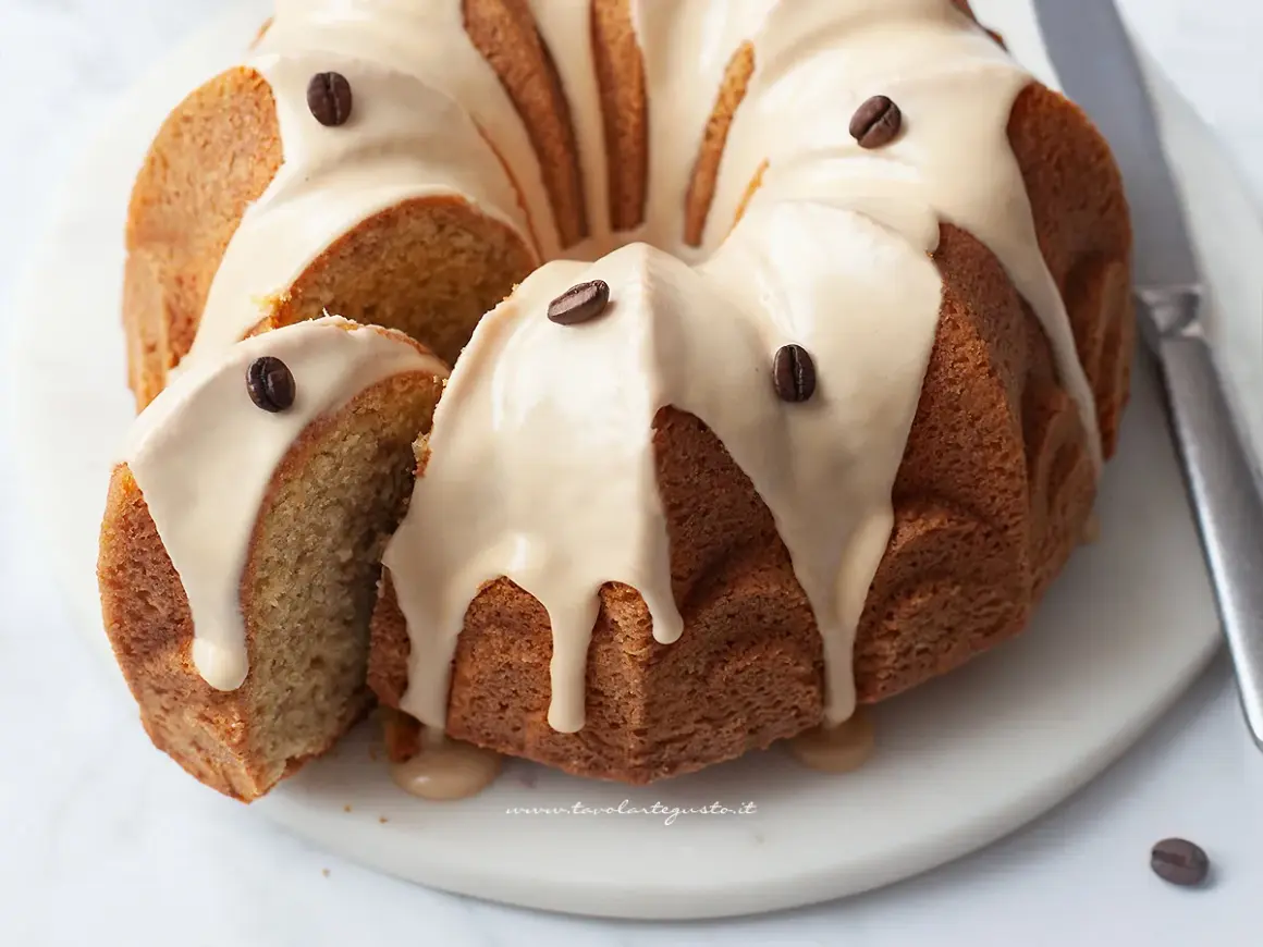 Delizioso ciambellone al caffè senza burro, con glassa e chicchi di caffè. Perfetto per la colazione o la merenda.