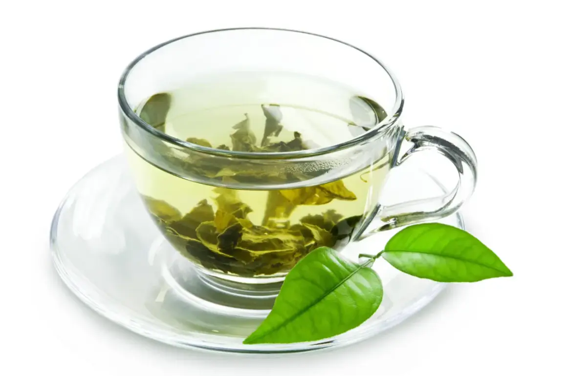 Tazza di tè verde con foglie infuse, un invito a scoprire i suoi benefici.