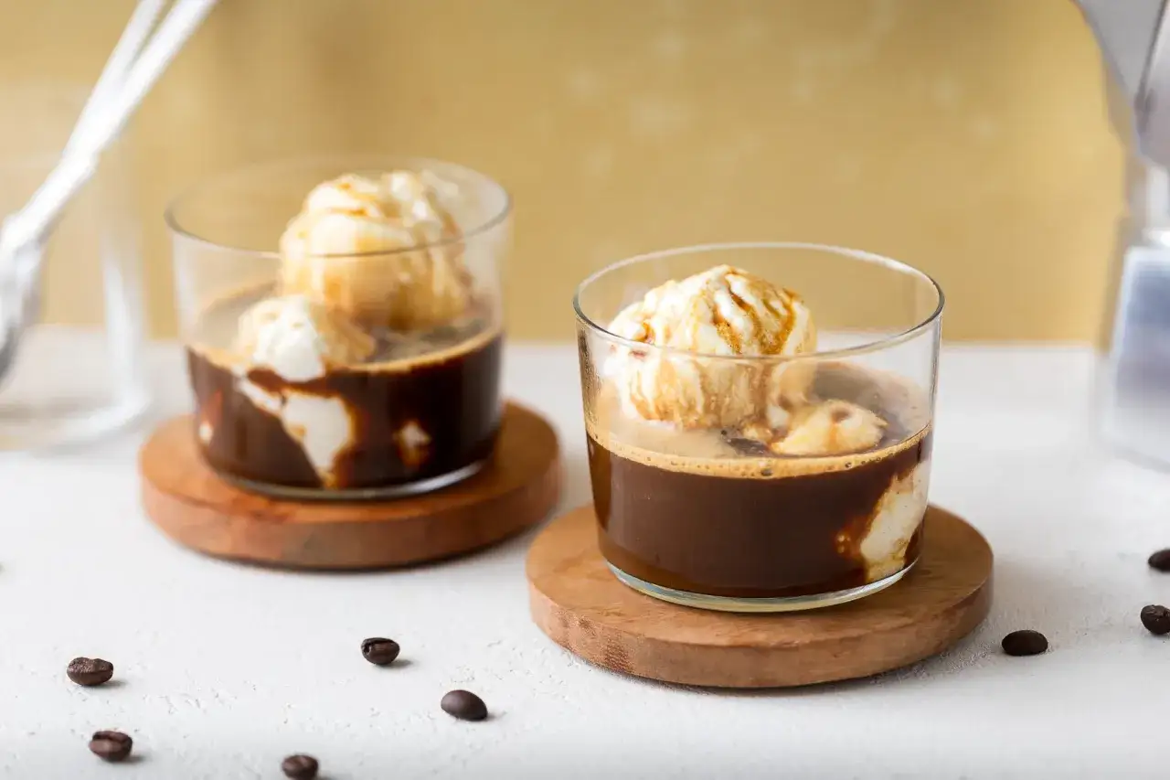 Due bicchieri di gelato affogato al caffè, con palline di gelato alla vaniglia che si sciolgono in un espresso caldo.