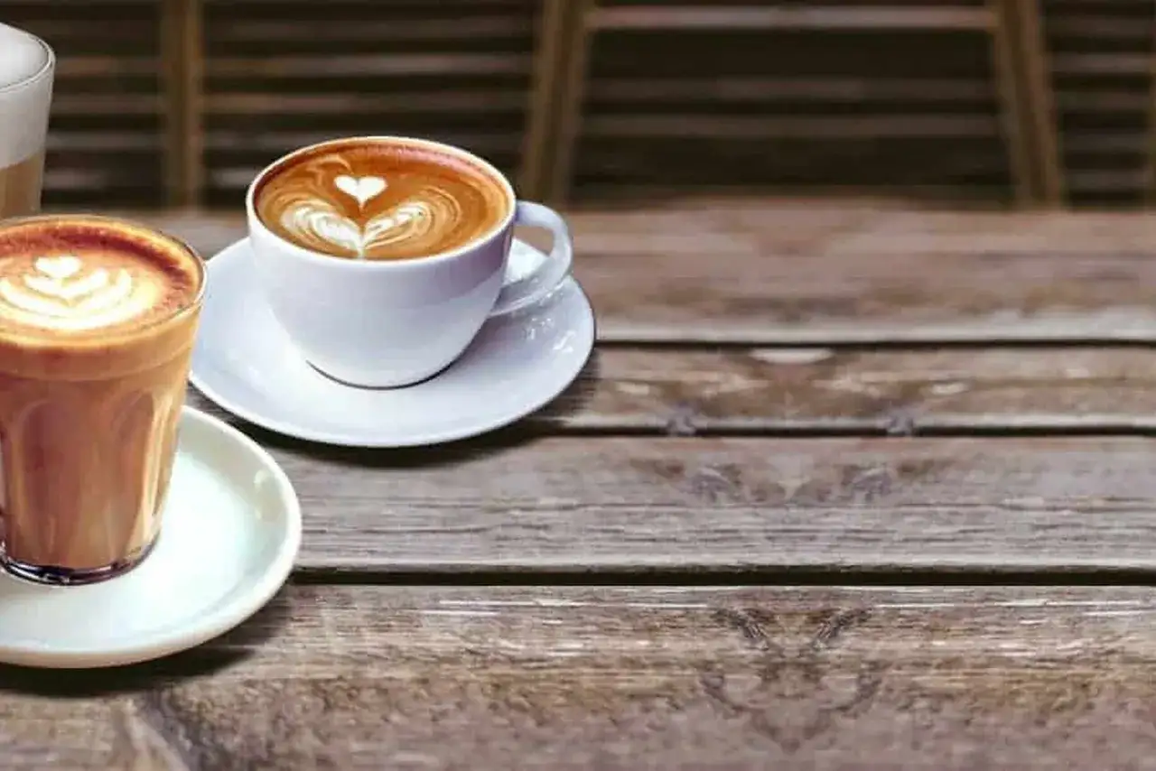 Due tazze di caffè con latte art, una in vetro e una in ceramica, mostrano la differenza tra caffelatte e cappuccino.