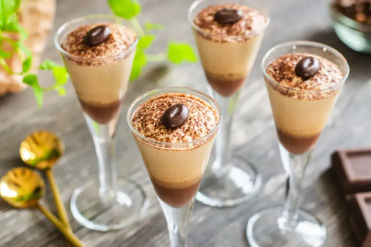 Quattro bicchierini di deliziosa mousse di caff&egrave;, guarniti con cacao e un chicco di caff&egrave;.