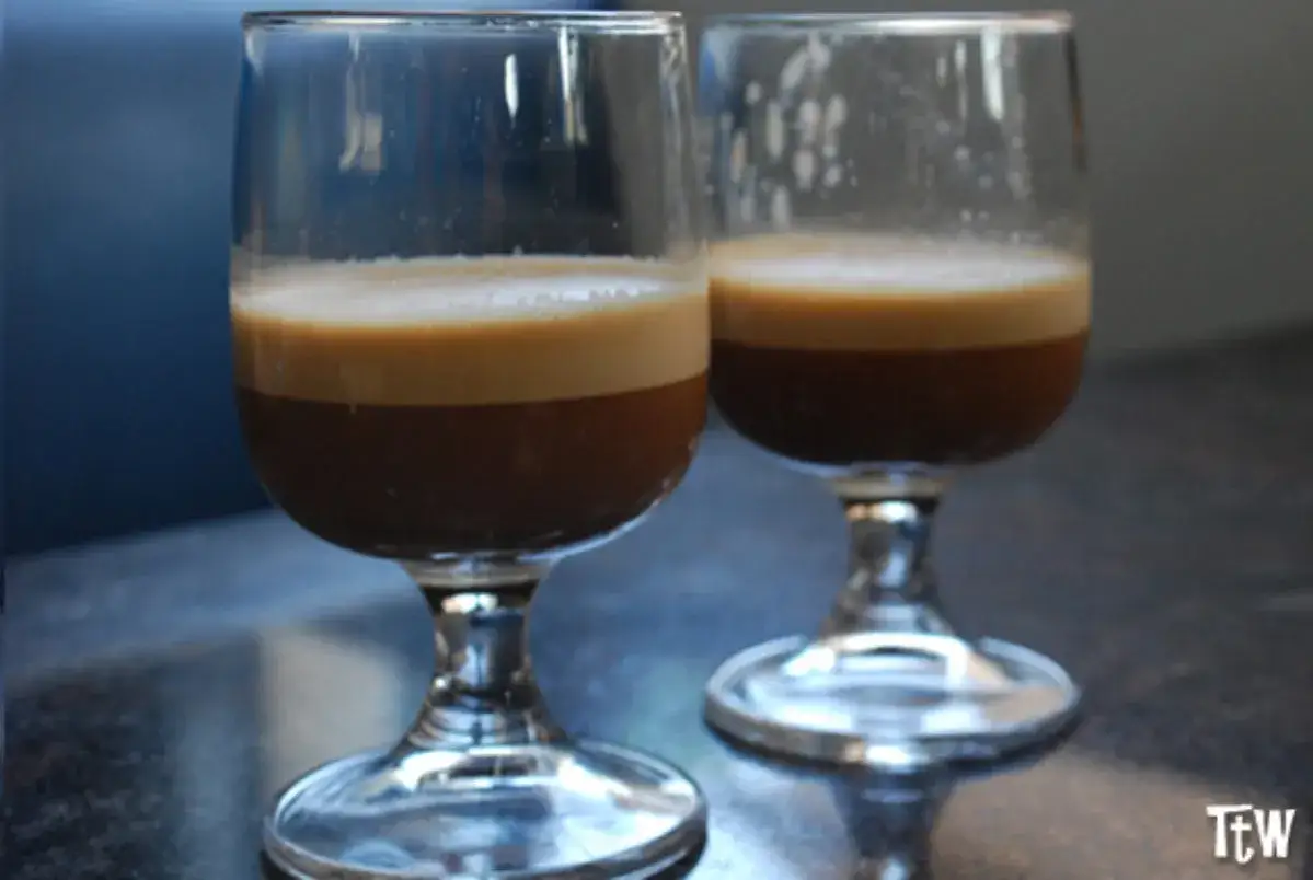 Due bicchieri di caff&egrave; speciale ricetta, con strati distinti di crema e caff&egrave; scuro.
