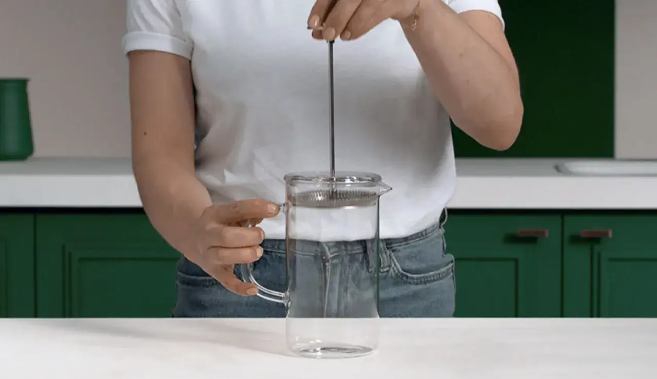 Una persona prepara un caffè con la french press.